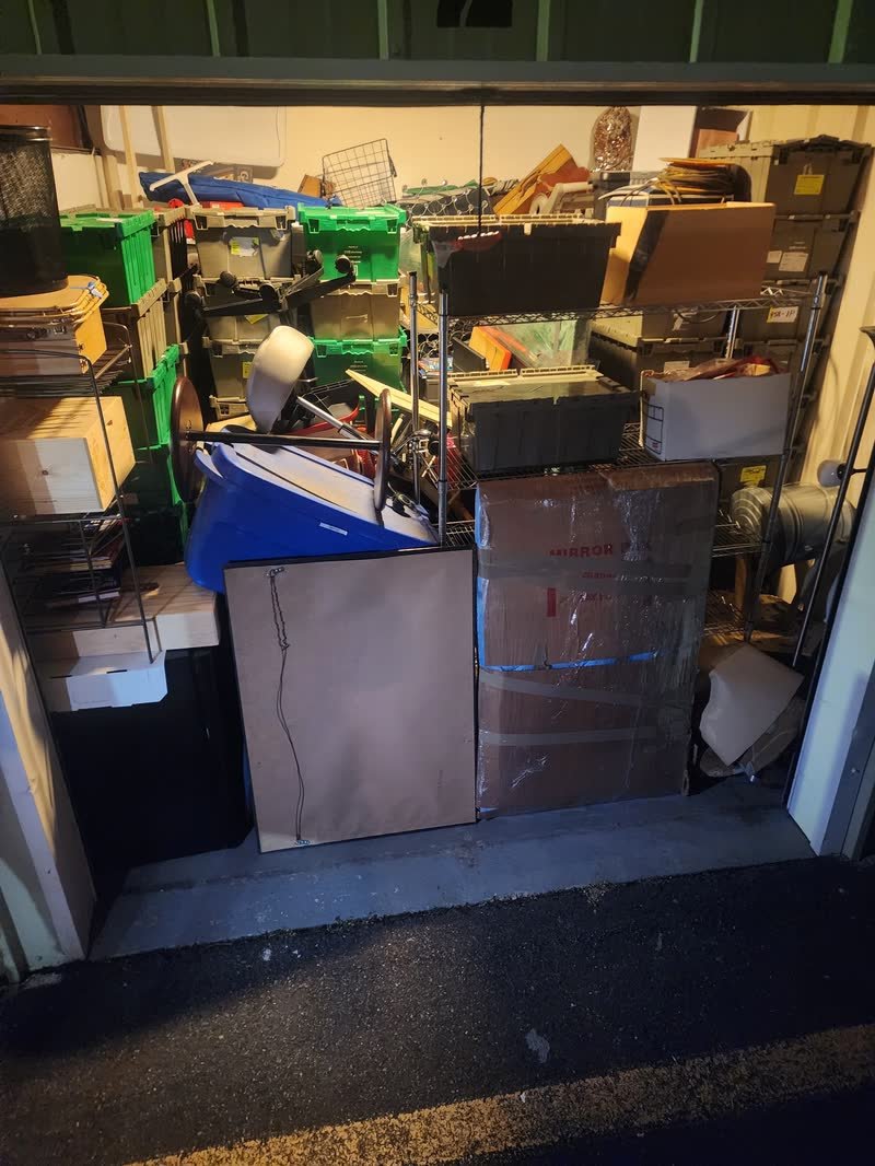 Garage packed floor to ceiling with furniture, boxes and a mattress before a Rich Brothers garage cleanout