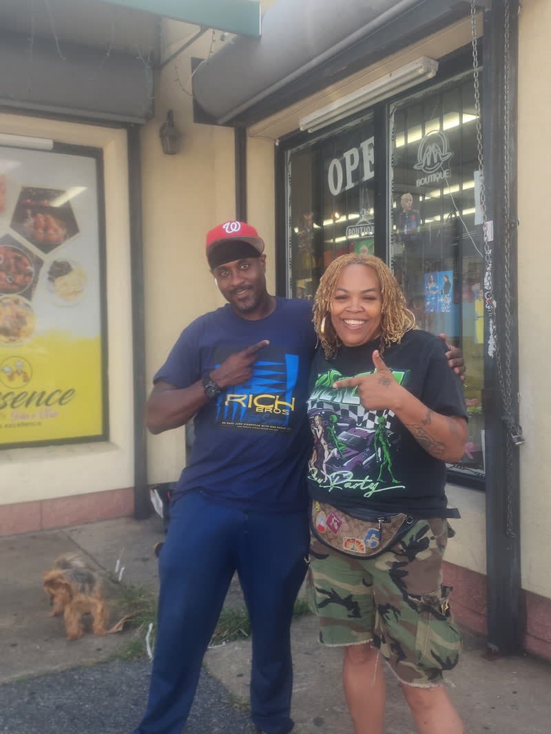 The Rich Brothers Bulky Trash team in branded shirts outside a storefront in Maryland